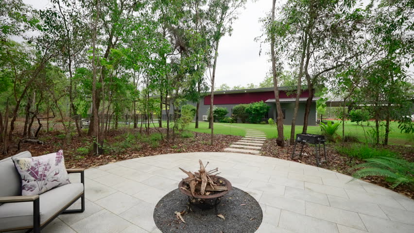 modern styling stone tiled communal fire pit with surrounding chairs. Large modern home with amazing fire place and stone path