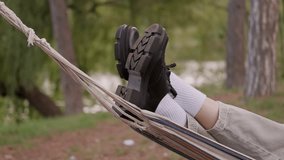 Close up video of legs with shoes on hammock