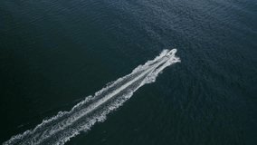 Drone video of a motorboat cruising at high speed in the deep blue ocean off the coast of Nova Scotia, Canada. Aerial drone filmed a motor boat on the open sea. Summer holiday in the Atlantic Ocean. 