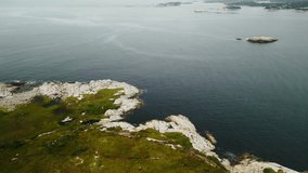 Cinematic drone shot ocean and rocky coast of nova scotia on cloudy summer day.Beautiful seascape with rocks and islands in the bay. Wildlife drone video of nova scotia deep turquoise rocky seascape 