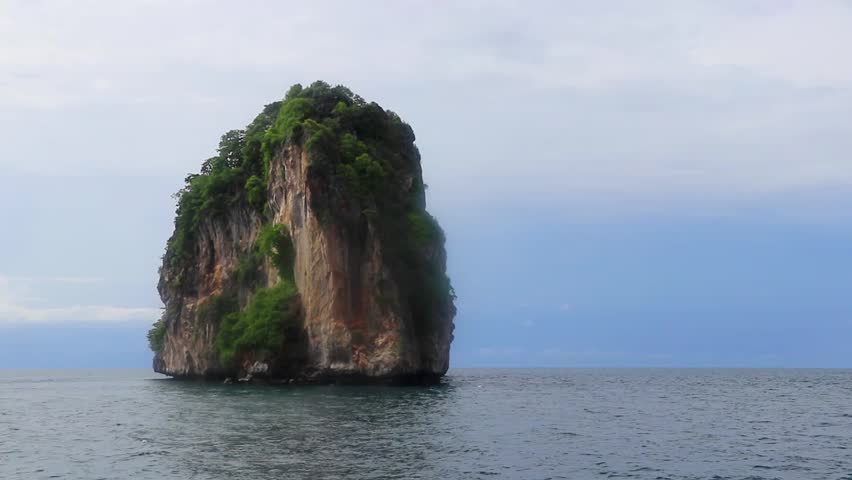 Limestone rocks hills mountains stormy clouds and turquoise blue water in Phang Nga Bay Krabi Thailand in Southeast Asia.