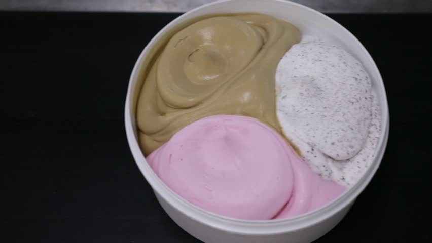 Ice cream factory. Top view of a conveyor belt transporting commercial ice cream pots with different flavors.