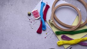 Supplies for hand embroidery.  Hoops with  canvas, scissors,  cotton threads. 
