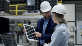 Female engineer and male director talking in modern industrial factory about solar panels installation, solar energy for company. Team management in manufacturing facility, green renewable energy for - Powered by Shutterstock - Get 15% off with code: PIKWIZARD15