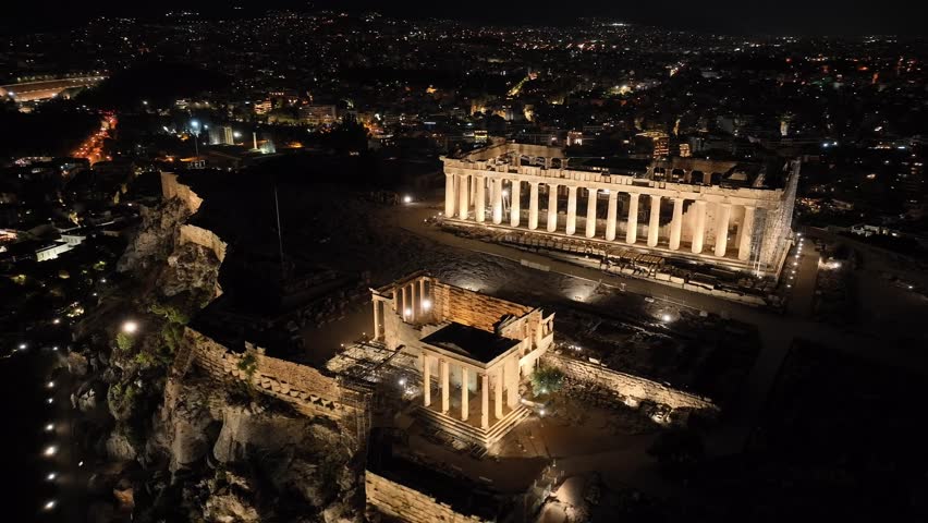 Aerial drone night cinematic video of iconic illuminated landmark Acropolis hill and the Masterpiece of Ancient times and Western civilisation - the Parthenon, Athens, Attica, Greece