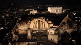Aerial drone night cinematic video of iconic illuminated landmark Acropolis hill and the Masterpiece of Ancient times and Western civilisation - the Parthenon, Athens, Attica, Greece