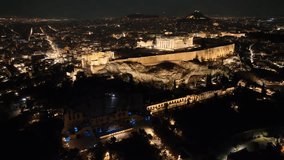 Aerial drone night cinematic video of iconic illuminated landmark Acropolis hill and the Masterpiece of Ancient times and Western civilisation - the Parthenon, Athens, Attica, Greece
