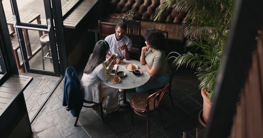 Friends, group and talking in coffee shop for communication catch up or university reunion, gossip or above. Man, woman and chat in cafe together as consumer for bonding lunch, diversity or social