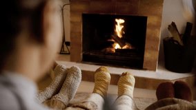 Family resting feet by fireplace. People warming feet with blanket and socks by cozy fire. - Powered by Shutterstock - Get 15% off with code: PIKWIZARD15