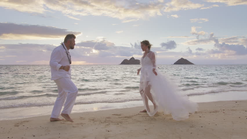 Expressive man and woman in wedding dress performing hilarious weird voodoo dance on sandy beach at sunrise. Funny passionate people making comic mating dance moves.Couple in love happy on wedding day Royalty-Free Stock Footage #3420608543