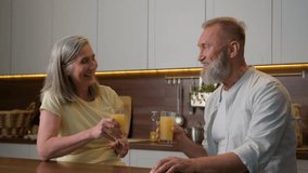 Caucasian married couple happy retired family elder man husband talking with mature woman wife in kitchen laughing male female drinking orange juice fresh fruits healthy nutrition love relationship - Powered by Shutterstock - Get 15% off with code: PIKWIZARD15