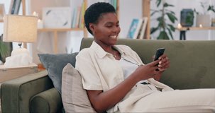 Phone, search and happy black woman on a sofa with social media joke, text or funny message in her home. Smartphone, comic and African female person in a living room with app for video streaming