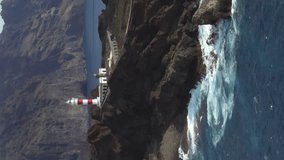 Aerial view of Punta de Teno lighthouse on Tenerife island, Spain. Beautiful landscape of rocky Tenerife coast with historic lighthouse, Canary Islands, Spain, vertical footage