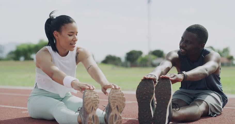 Happy people, stretching and fitness in running, exercise or getting ready for sport on outdoor stadium track. Man, woman or athletic friends in warm up or leg stretch for preparation, race or sprint