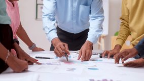 Group of unrecognizable corporate startup employees discussing from charts during meeting at office - concept of team meeting, data analysis and review. - Powered by Shutterstock - Get 15% off with code: PIKWIZARD15