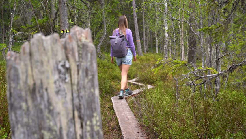 Woman hikes through the forest.