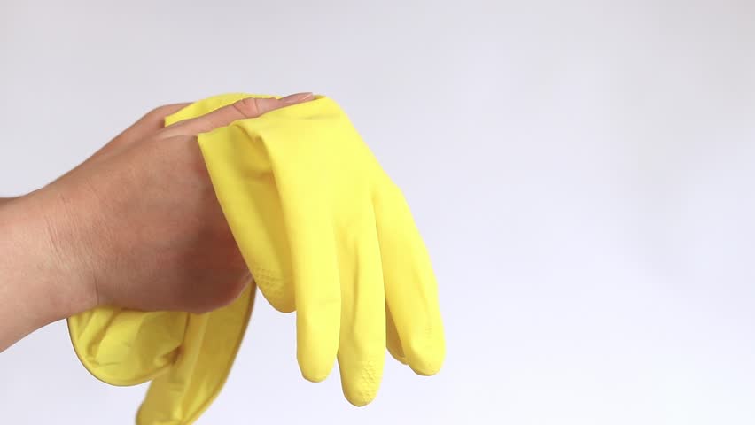 Household gloves, yellow. Latex gloves for cleaning the room and washing dishes, size M. Women's hands put on gloves on a light background, cleaning, close-up Royalty-Free Stock Footage #3421016709