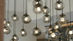Collection of modern spherical glass pendant lights hanging from ceiling. Bright bulbs emitting warm and inviting glow. Concept of illumination and design - Powered by Shutterstock - Get 15% off with code: PIKWIZARD15