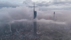 Aerial view time lapse 4k video of Kuala Lumpur city center view at dawn overlooking the city skyline in Federal Territory, Malaysia during low clouds sunrise. 
