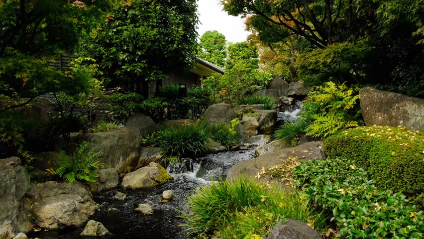 Beautiful waterfall in traditional Japanese garden in autumn, Asakusa Tokyo.