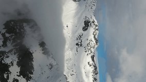 Flying over snow-capped mountains in clouds. Aerial landscape in Adamello Brenta, Italy. Vertical video - Powered by Shutterstock - Get 15% off with code: PIKWIZARD15