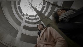 Lifestyle Portrait of Two Young Women Watching Tower Building Together