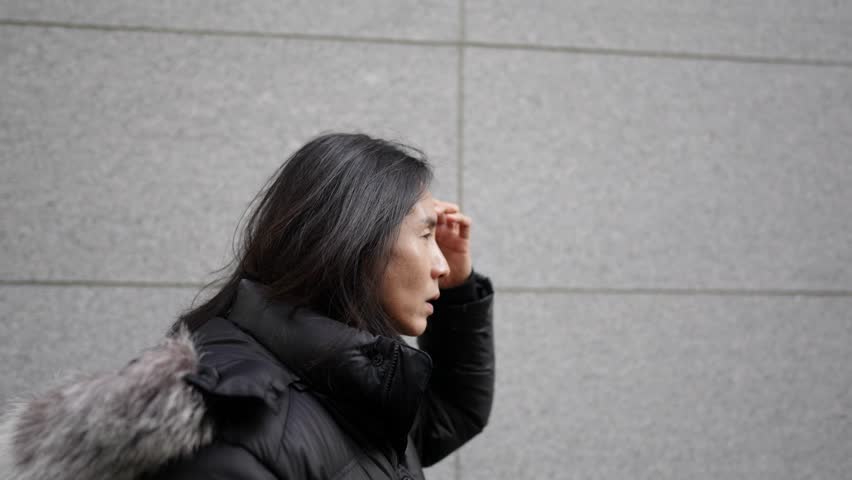 Slow-motion video of a Korean man in his 30s walking on the main street of Myeong-dong, Seoul, South Korea in the cold winter