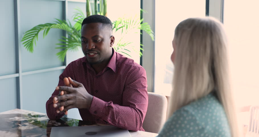 African businessman, sales manager, bank advisor consulting to young female client, shaking hands, make profitable deal, succeed goal, finish successful meeting, negotiation in company conference room Royalty-Free Stock Footage #3421328833