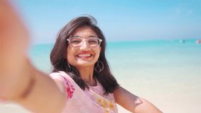 Beautiful young Indian woman taking selfie at beach during summer vacation at Agatti, Lakshadweep, India. Selfie video of Girl showing beach. Smiling tourist having fun outside on summertime holidays