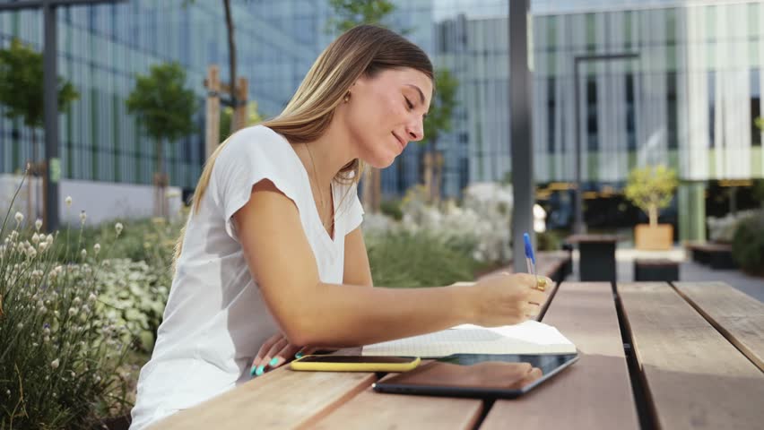 Female University student freelancer using digital tablet working at city Campus