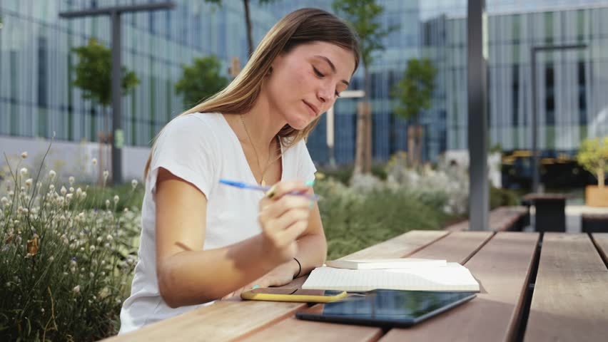 Female University student freelancer using digital tablet working at city Campus
