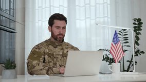 Portrait of soldier serving in armed forces sitting at table with USA flag, supporting information systems and developing software on personal laptop indoors. Concept of military and technology. - Powered by Shutterstock - Get 15% off with code: PIKWIZARD15