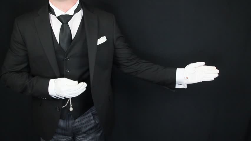 Butler or Hotel Concierge in Formal Dark Suit and White Gloves Making a Welcoming Gesture With Arm. Service Industry and Professional Hospitality.