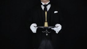 Butler or Waiter in Formal Dark Suit and White Gloves Holding Silver Serving Tray and Ringing Bell for Dinner. Service Industry and Professional Hospitality. - Powered by Shutterstock - Get 15% off with code: PIKWIZARD15