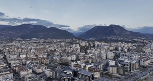 aerial video of a flight over the city with mountains and clouds
