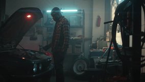 Auto mechanic. African American repairman working on car engine in auto workshop with screwdriver. View under hood of car. Service and maintenance of cars. Repair of car breakdowns. - Powered by Shutterstock - Get 15% off with code: PIKWIZARD15