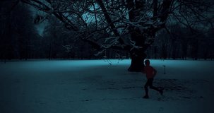 Running woman in the snow on a winter evening. A woman in a pink sports jacket is doing fitness outdoors. Concept of sport, leisure and freedom. 4K slow motion video