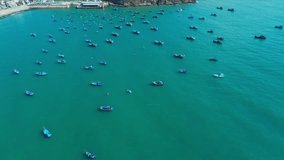 Seascape with turquoise water and anchored Vietnamese fishermen's fishing boats, aerial shot. Travel concept, sea nature.