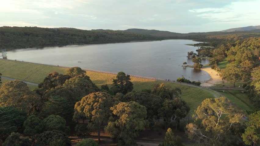 Lake and dam in golden hour sunset light forward motion