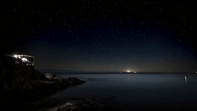 Night starry sky time lapse with house on the ocean, galaxy, ocean night, Vancouver Island. 4K 24FPS