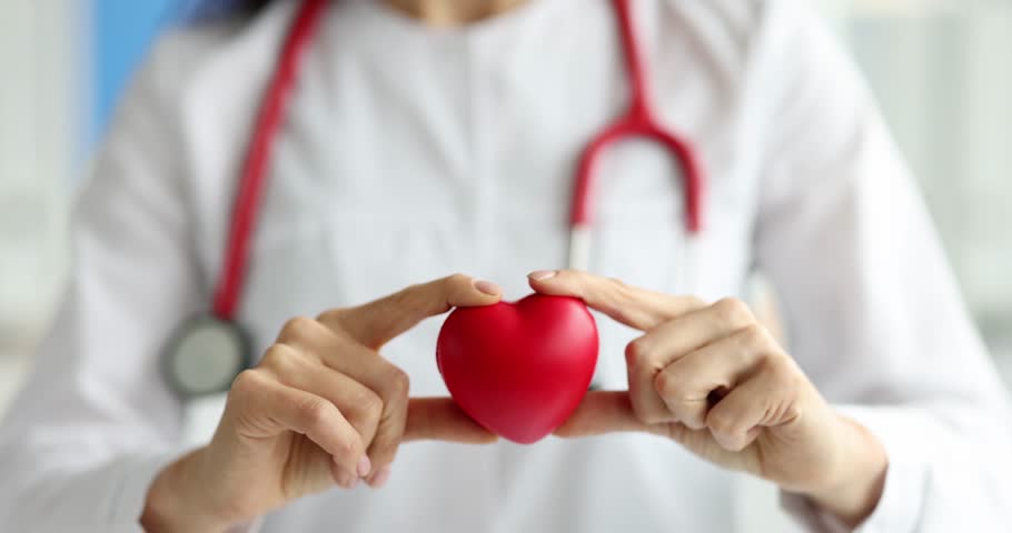 Doctor cardiologist holding red toy heart in clinic closeup 4k movie slow motion. Donation concept Royalty-Free Stock Footage #3422107351
