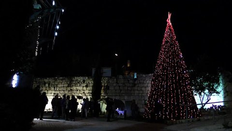 Tourists visit Christmas tree near the Church of St Mary Magdalen in Miilya Israel, December 20, 2017