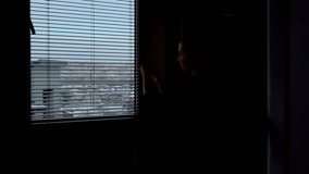 Silhouette of a woman opening the blinds. Wooden blinds that open on large windows in the interior. - Powered by Shutterstock - Get 15% off with code: PIKWIZARD15