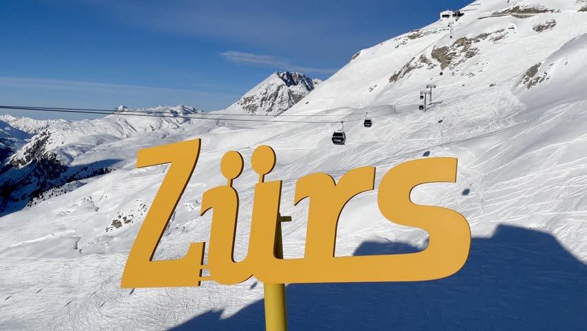Panoramic view of pistes, ski slopes and mountains of noble skiing resort Lech Zürs, Arlberg. Zürs sign with Flexenbahn in the background.