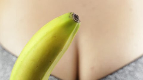 Young woman peeling and eating banana