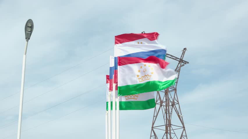 The flag of Tajikistan and the Russian flag waving side by side in the wind. Friendship of nations. 4K. Royalty-Free Stock Footage #3422415243