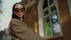 Beautiful woman model in stylish clothes and trendy sunglasses posing and looking at camera on street. Confident attractive female in fashionable outfit outdoors - Powered by Shutterstock - Get 15% off with code: PIKWIZARD15