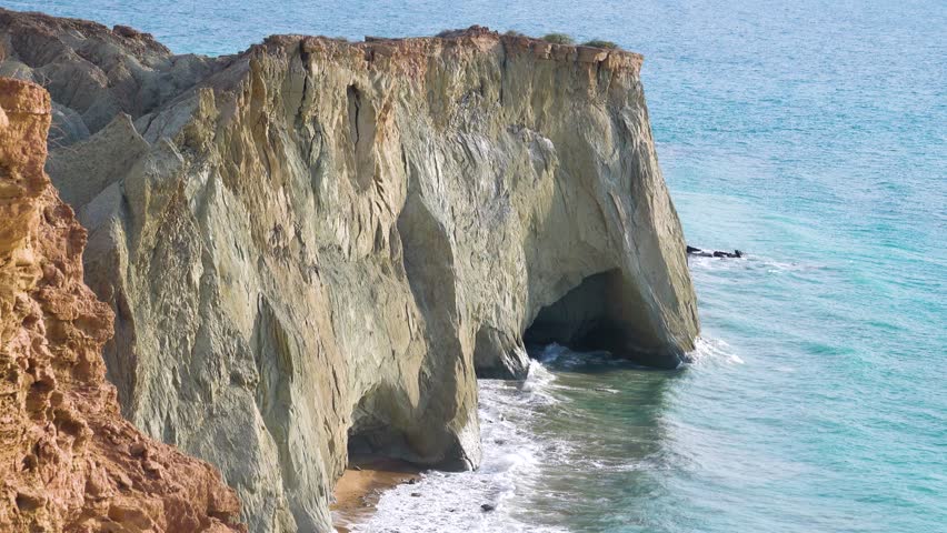 Seascape. Rocky steep coast with grottoes. Island of Hormuz, Strait of Ormuz Royalty-Free Stock Footage #3422446889