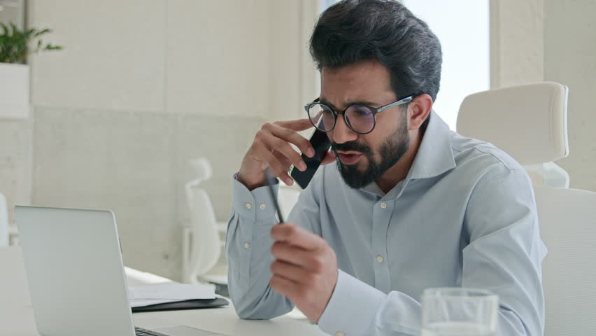 Busy Arabian Indian muslim man successful entrepreneur employer CEO boss leader executive manager businessman talking mobile phone in office workplace using laptop consult client business discussion Royalty-Free Stock Footage #3422486043