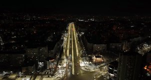 Panoramic aerial drone view of road toCity Gates of Chisinau in Dacia Boulevard. View of road, in night time, buildings of Chisinau at winter season, capital city of Republic of Moldova. 4K video.